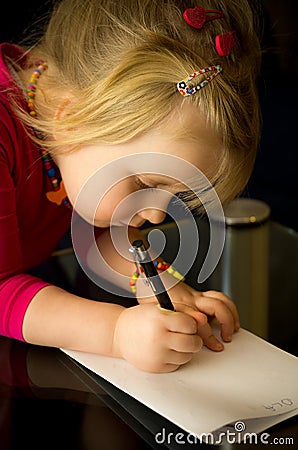 Little girl drawing with pen