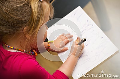 Little girl drawing with pen