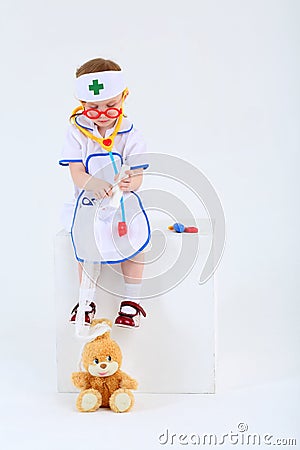 Little girl dressed as nurse bandages head to toy rabbit