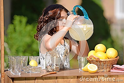 Little girl drinking from lemonade pitcher