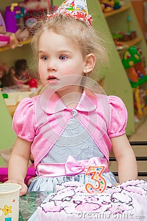 Little girl eating cake at birthday party