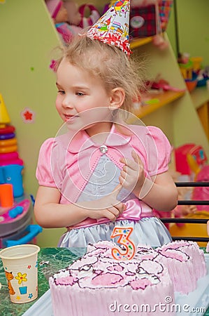 Little girl eating cake at birthday party