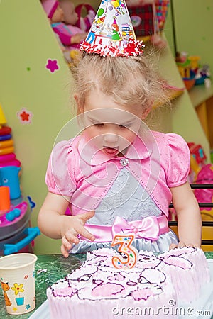 Little girl eating cake at birthday party