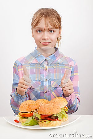 Little girl with hamburgers showing thumbs up