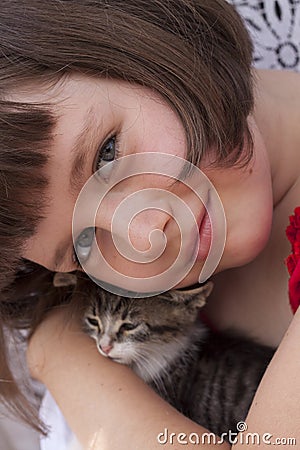 Little girl hugging kitten