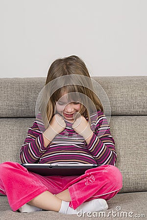 Little girl playing with a digital tablet