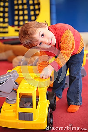 Little girl plays with car in kindergarten