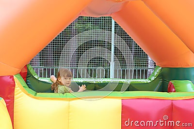 Little girl plays in colored air trampoline