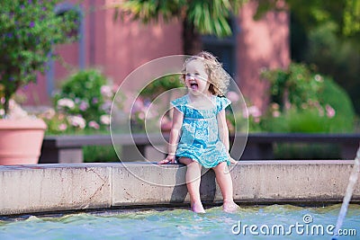 Little girl refreshing in a fountain