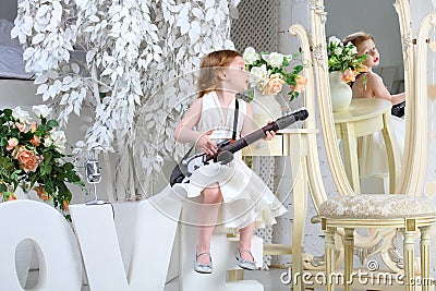 A little girl sings and plays guitar