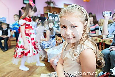 Little girl sitting in kindergarten class room at music lesson