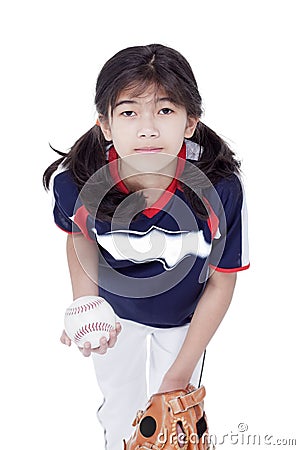 Little girl in softball team uniform ready to throw a pitch