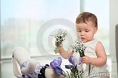 A little girl is spending time with flowers