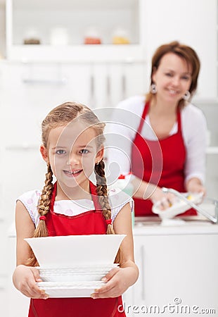 Little girtl helping mother to do the dishes