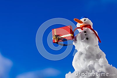 Little happy snowman with christmas gift box outdoor. Winter season.