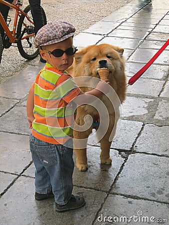 Little Italian boy treats ice cream to dog