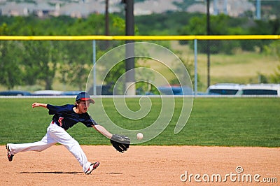 Little league boy reach out to catch ball