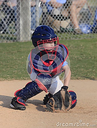 Little league Catcher Goes for a Pitch in the Dirt