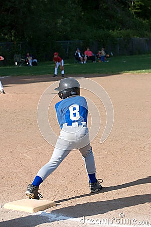 Little League player on base.
