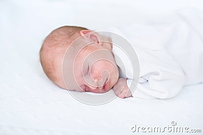 Little newborn baby boy on white knitted blanket