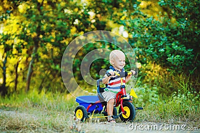 Little smiling boy on toy bicycle