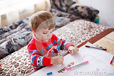Little toddler boy drawing with colorful pens