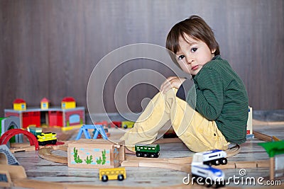 Little toddler boy playing with wooden railway