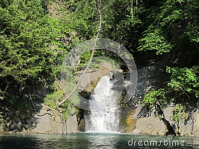 Little waterfall flows into the Blue Lake, Grenoble