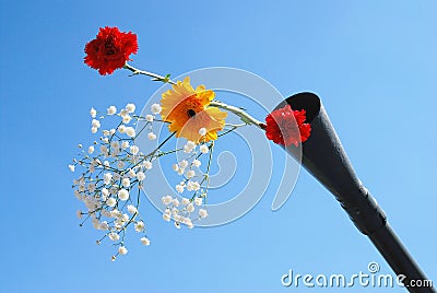 Live flowers stick out of a gun barrel.
