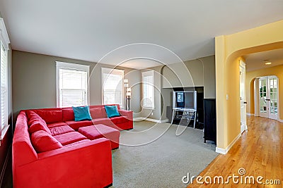 Living room with bright red couch and TV