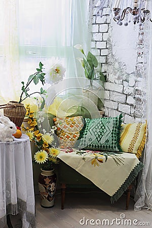 Living room interior corner with colored pillows, vases and flowers