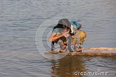 Local girl drinking from water reservoir, Khichan village, India