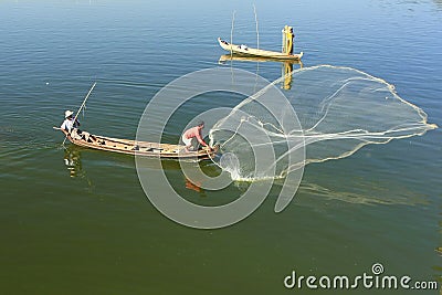 Local man fishing with a net from a boat, Amarapura, Myanmar