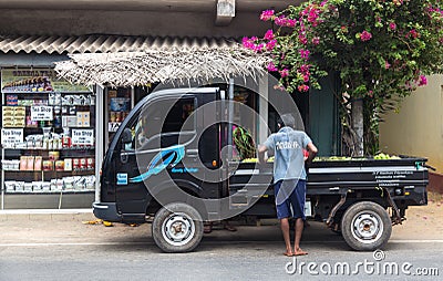 Local man standing by the black truck parked in front of the tea shop.