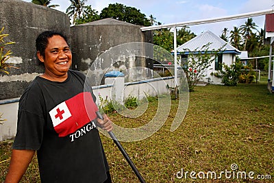 Local woman cleaning church yard, Ofu island, Tonga
