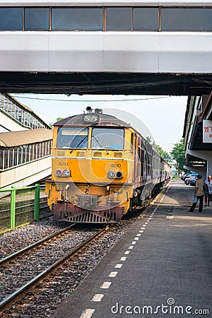 Locomotive with train arrives at railway station in Thailand