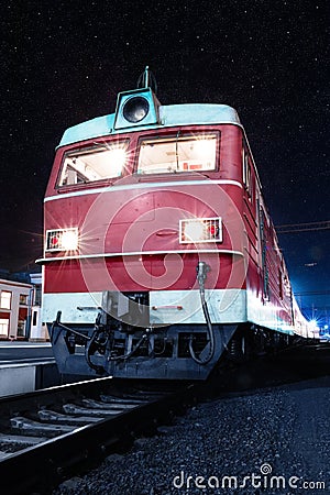 Locomotive of a train on a platform at night