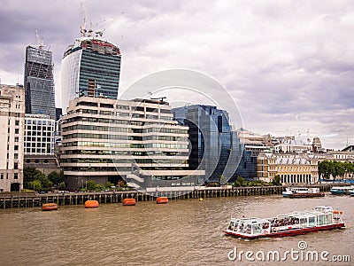 River Thames to modern office buildings, with a tourist cruise boat 