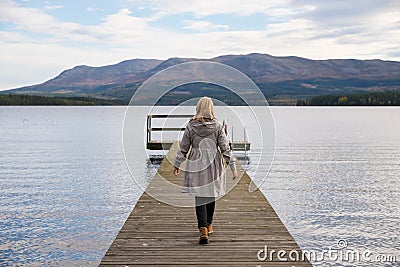 Lonely woman walking on a pier