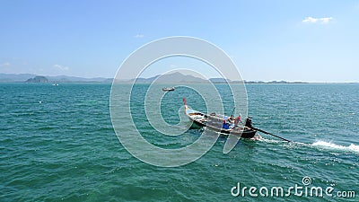 Long tail boat with the sailor on the open sea in Thailand near the Koh Muk Island