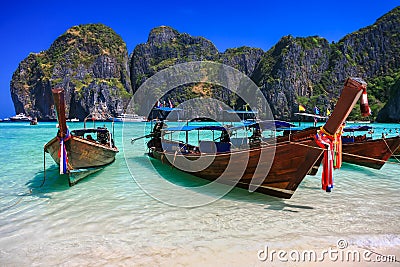 Long tail boat on white sand beach with crystal clear sea