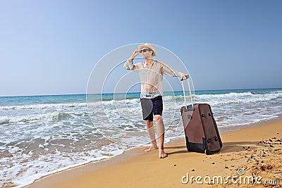 Lost young tourist with his baggage on a beach