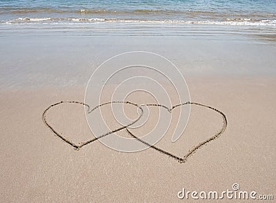 Love heart symbols in sand on tropical beach