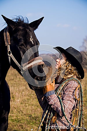 Lovely blond woman standing by horse