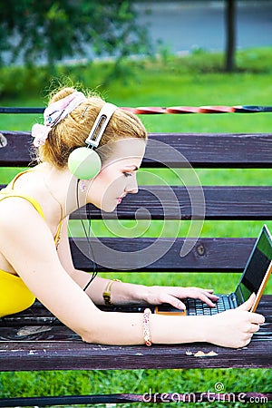 Lovely woman having rest in the park with laptop