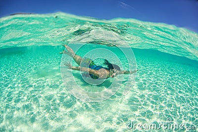 Lovely woman wearing dress and swimming in the ocean