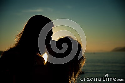 Loving couple kissing in the sunset at the beach