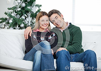 Loving Couple Sitting On Sofa During Christmas