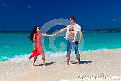 Loving couple walk through the tropical beach