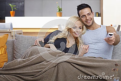 Loving couple watching tv at home